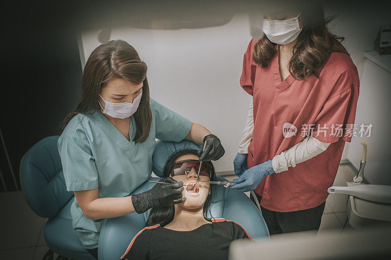 directly above dental examination inspection on chinese teenage girl open mouth